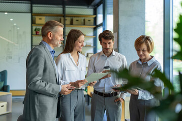 Group of business people standing together and discussing their work and projects, having a team...