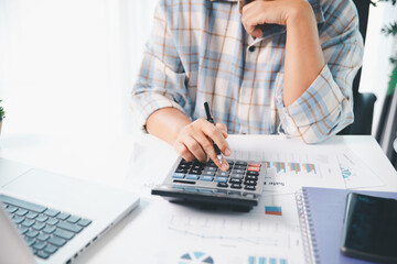 Accountant working on desk using calculator for calculate finance report in office. business...