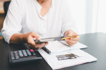 Using calculating machine, household carefully manages each bill and expense to plan financial...