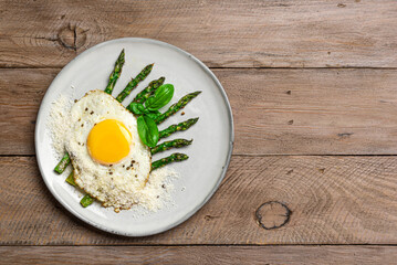 Fried egg with green asparagus and grated parmesan cheese, healthy breakfast