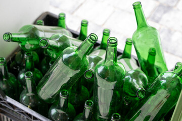 Man green empty glass bottles in a black plastik box ready to be retrieved to the shop