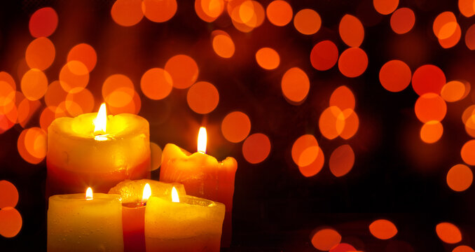 Candles glowing against a bokeh background.