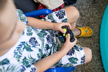 Little boy playing with toys near blue pool