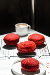 Delicious red velvet donuts on a white table. Red velvet doughnuts topped with cheese.