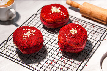 Delicious red velvet donuts on a white table. Red velvet doughnuts topped with cheese.