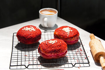 Delicious red velvet donuts on a white table. Red velvet doughnuts topped with cheese.