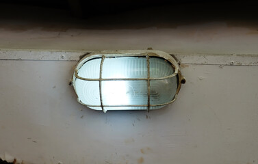 An outdoor wall light, commonly known as a bulkhead light or a marine-style light. It features an...