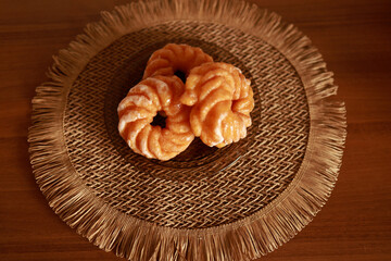 round donuts on a plate with a brown woven placemat
