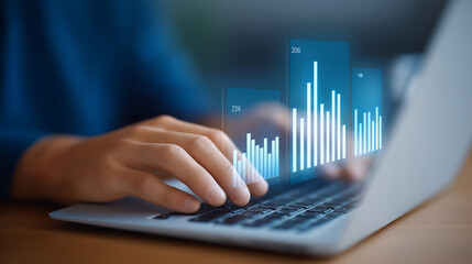 Close-up of hands typing on a laptop with financial dashboards