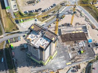Aerial view of high-rise under construction with cranes on site