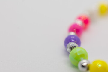 Colorful string of beads with a silver bead in the middle. The beads are in various colors and sizes, creating a vibrant and eye-catching design.
