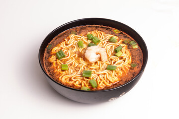 Delicious bowl of seafood ramen featuring shrimp, green onions, and rich broth served in a black bowl