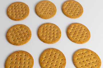 Round crispy cookies arranged in a neat pattern on a white surface ready for serving or baking