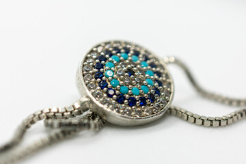 Blue and white necklace with a blue stone in the center. The stone is surrounded by smaller stones...