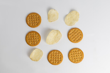 Various types of crackers arranged on a white surface for a creative snack presentation, showcasing different shapes and textures in a minimalist setup