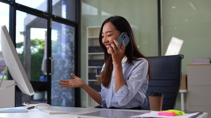 Asian businesswoman involved in cellphone call conversation giving professional consultation to client or negotiating project. - Powered by Adobe