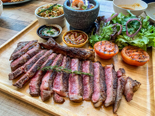 Perfect Grilled medium rare Ribeye Steak Platter with Sides and thai style sauce