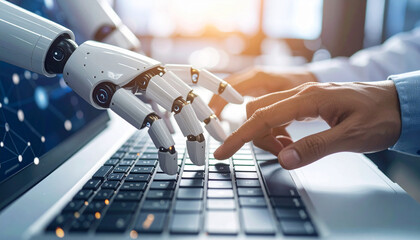 A robot hand and a human hand are typing on a laptop keyboard, showcasing the collaboration between humans and artificial intelligence.
