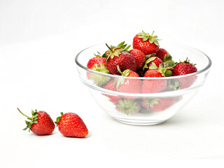 Ripe strawberries. Glass bowl with ripe strawberries on white background