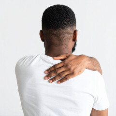 Person with short curly hairstyle and dark skin shows hand on their shoulder, expressing concern about mental health and physical discomfort