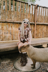 Young woman in vintage outfit interacts with friendly capybara at rustic setting, showcasing bond...