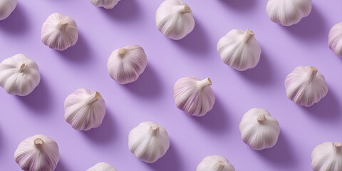 Fototapeta premium Garlic bulbs on a colored background, colorful garlic pattern. Panoramic banner