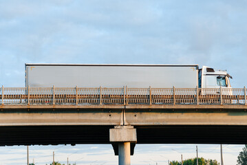 white truck driving along road at sunset in summer, transportation and logistics concept