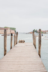 Wooden pier extending into a serene lagoon on a cloudy day