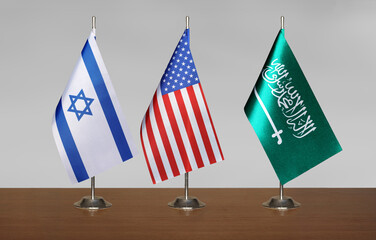 Flags of Israel, USA and Saudi Arabia on gray blurred background