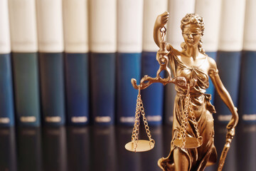 statue Themis representing justice and fairness  with law books to consulting , focus  in foreground