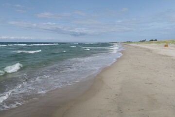 Wellen branden am Strand des Ostseeorts Dierhagen auf dem Fischland in Mecklenburg-Vorpommern. Es ist ein sonniger und stürmischer Sommertag.