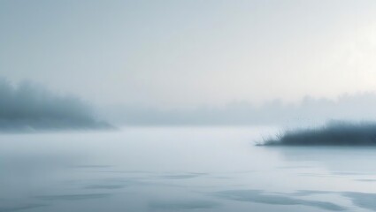 Misty morning over frozen lake with bare trees and reeds
