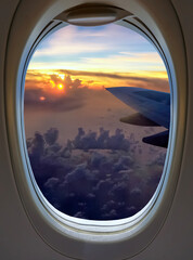 Airplane wing and sunset sky view from window seat during vacation travel flight.