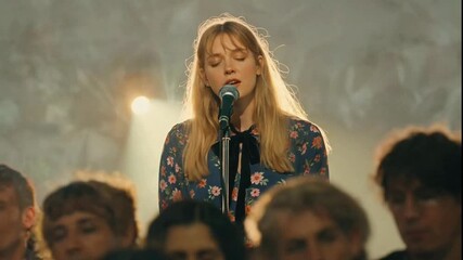 Emotional Young Woman Singing into a Microphone on a Hazy Stage.