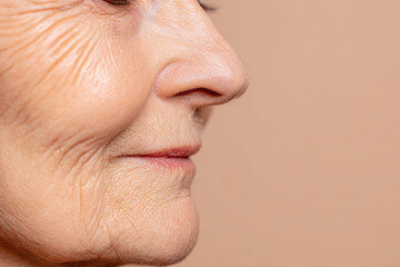 Elderly woman face closeup minimal makeup smooth skin visible wrinkles partial profile natural aging healthy complexion serene expression beige background