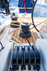Close-up of rope clutches and winches on the deck of a sailing yacht near Croatia. Sailing equipment, control systems and technical detail of life at sea.