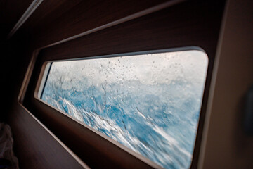 View through the bow cabin window of a sailing yacht leaning into the sea near Croatia. Sailing in...