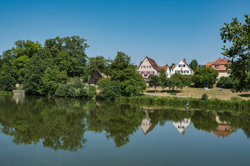 Reflection of houses in the calm waters of the Rothenburg Pond in Dinkelsbühl, Middle Franconia