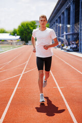 Fototapeta premium Young Male Athlete Running on Track – Outdoor Training, Fitness and Competition Concept