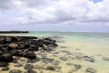 Sweeping coastal views in Blue Bay, Mauritius: rugged volcanic cliffs meet turquoise lagoon waters, coral reefs —perfect for travel, nature, and adventure themes.