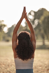 Woman practicing yoga and stretching in the park on a hot sunny summertime day.