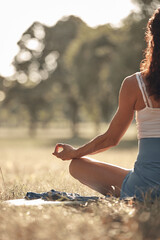 Woman practicing yoga and stretching in the park on a hot sunny summertime day.