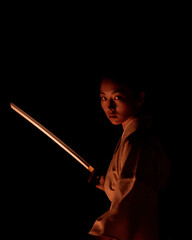 Female Samurai Holding Katana in Dramatic Lighting