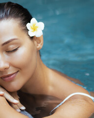 Close-Up of Smiling Woman with Flower Relaxing in Luxury Spa Pool