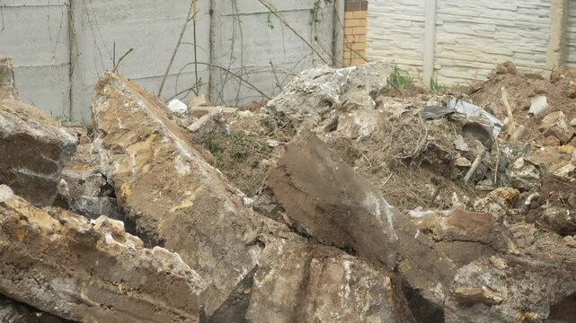 Demolition, construction, debris falling onto a concrete pile at a building site.