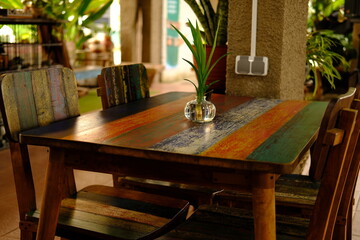 Cozy Cafe Interior with Decorative Plant, Colorful Reclaimed Wood Table with Greenery, Simple Plant...