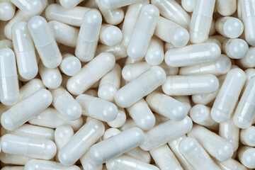 Close-up of many white supplement capsules. Macro photo of generic pills or vitamins. Health,...