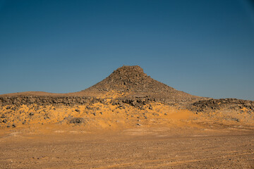 Ash-covered hills in Egypt's Black Desert under a clear sky, scenic and remote landscape. Volcanic	