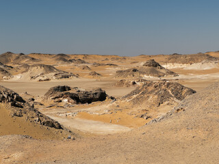 Ash-covered hills in Egypt's Black Desert under a clear sky, scenic and remote landscape. Volcanic	