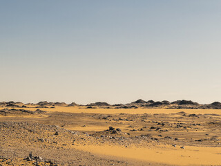 Ash-covered hills in Egypt's Black Desert under a clear sky, scenic and remote landscape. Volcanic	